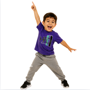 Small Boy in purplr t-shirt in disco dance pose. 